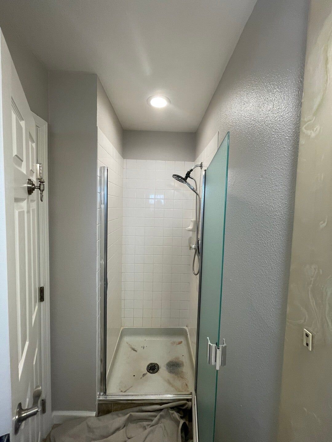 Shower with new tile-look walls and glass door, before