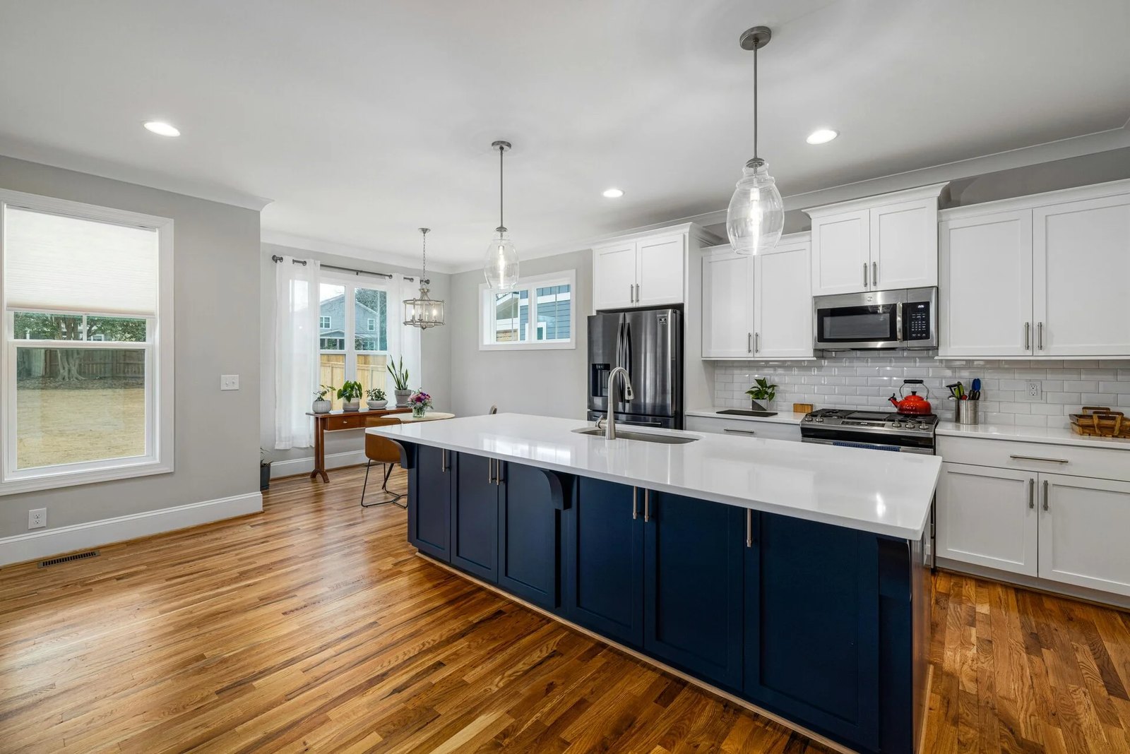Kitchen visualizer example: dated oak kitchen previewed with white cabinets and a navy island, after